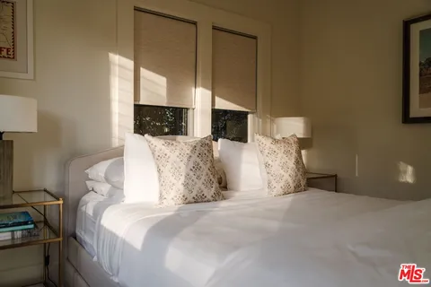 a large bed sitting in a bedroom next to a window
