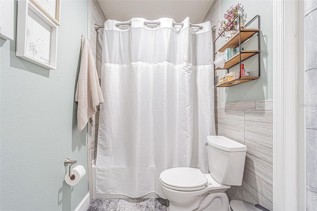 9809 La Rita Place Riverview, FL 33569 - Photo 18 of 59 a white toilet sitting next to a white curtain