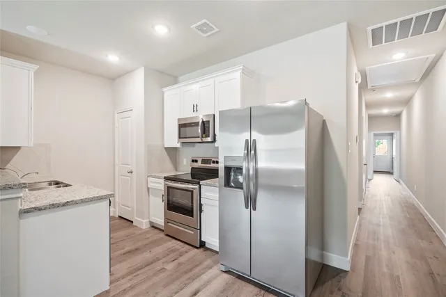 a kitchen with stainless steel appliances a refrigerator sink and microwave