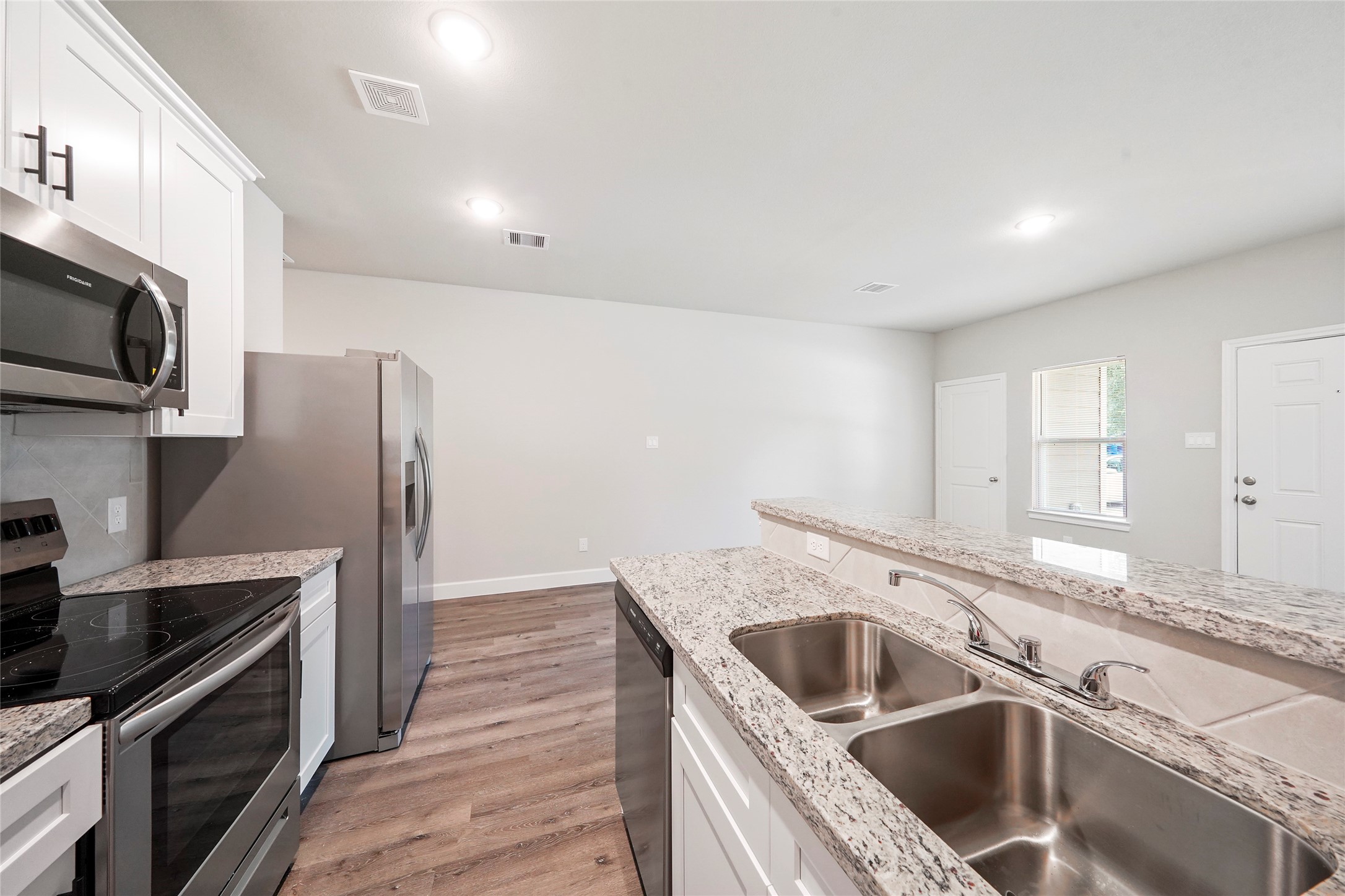 412-414 Avenue H Conroe, TX 77301 - Photo 6 of 25 a kitchen that has a sink wooden cabinets and stainless steel appliances