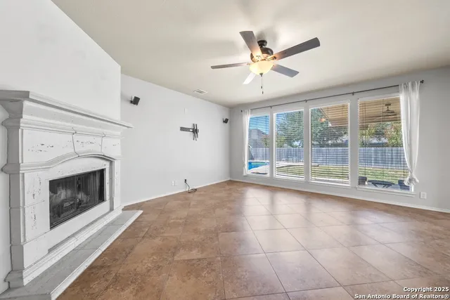 a view of an empty room with glass door and a fireplace