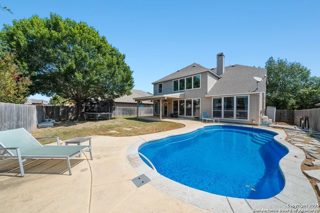 a view of a house with swimming pool and sitting area