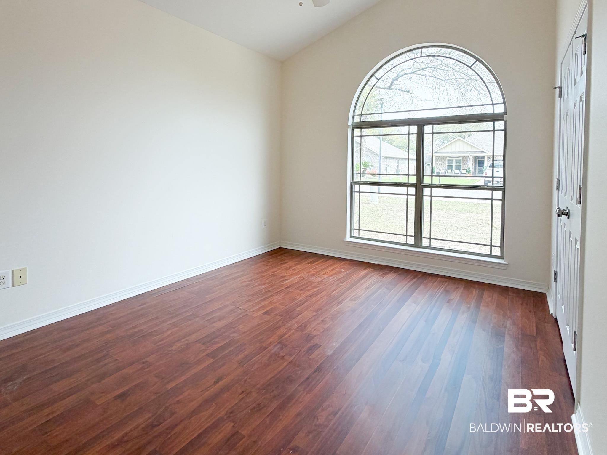 7332 Raintree Lane Gulf Shores, AL 36542 - Photo 16 of 21 Spare room featuring lofted ceiling, dark wood-type flooring, and ceiling fan