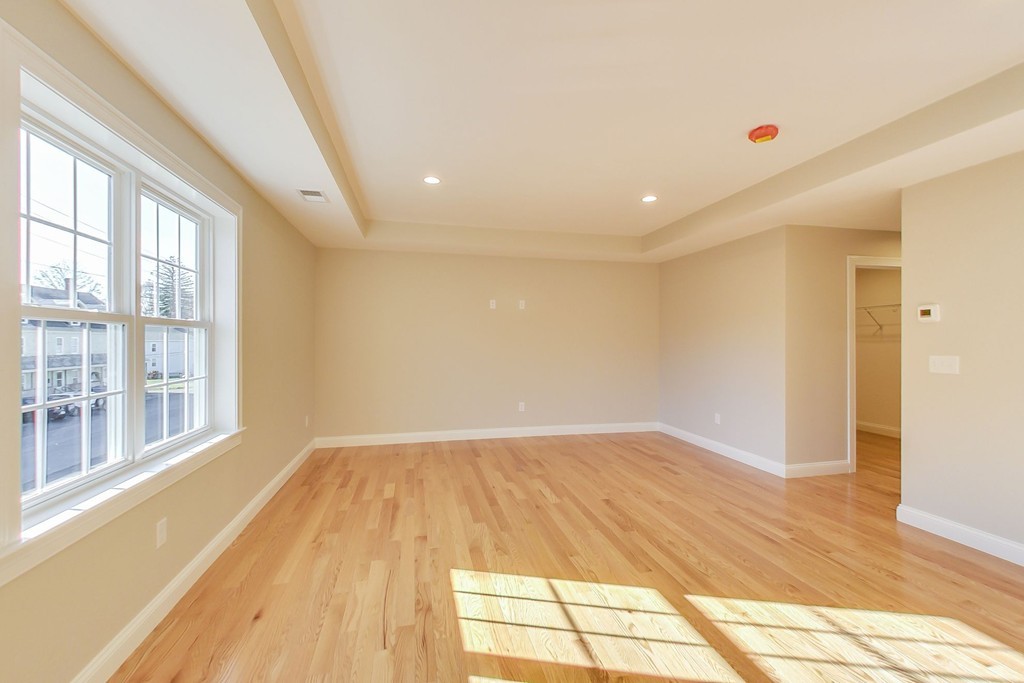 38 Cherry Street, Unit B Hudson, MA 01749 - Photo 25 of 38 a view of empty room with wooden floor and fan