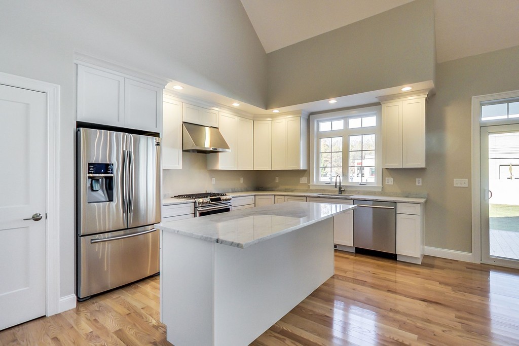 38 Cherry Street, Unit B Hudson, MA 01749 - Photo 6 of 38 a kitchen with granite countertop stainless steel appliances a refrigerator cabinets and wooden floor