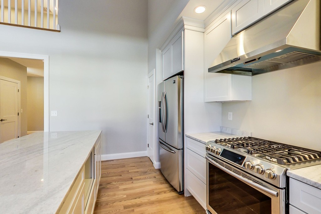 38 Cherry Street, Unit B Hudson, MA 01749 - Photo 9 of 38 a kitchen with stainless steel appliances granite countertop a stove and a refrigerator