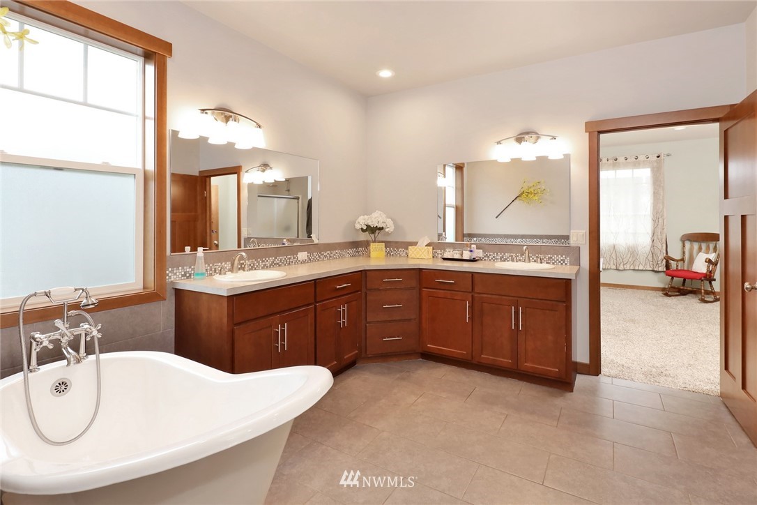804 Red Maple Loop Everson, WA 98247 - Photo 24 of 40 a large bathroom with a double vanity sink a mirror and a bathtub