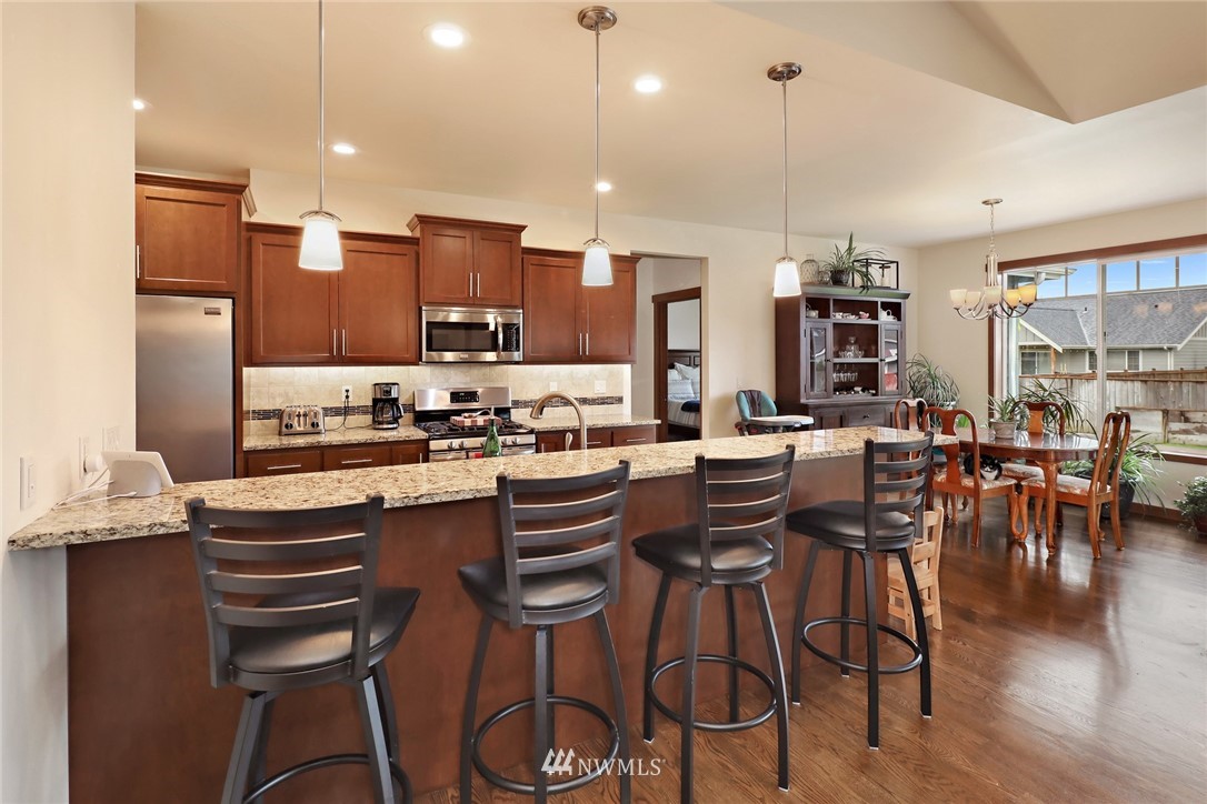 804 Red Maple Loop Everson, WA 98247 - Photo 6 of 40 a kitchen with stainless steel appliances kitchen island granite countertop a dining table chairs and white cabinets