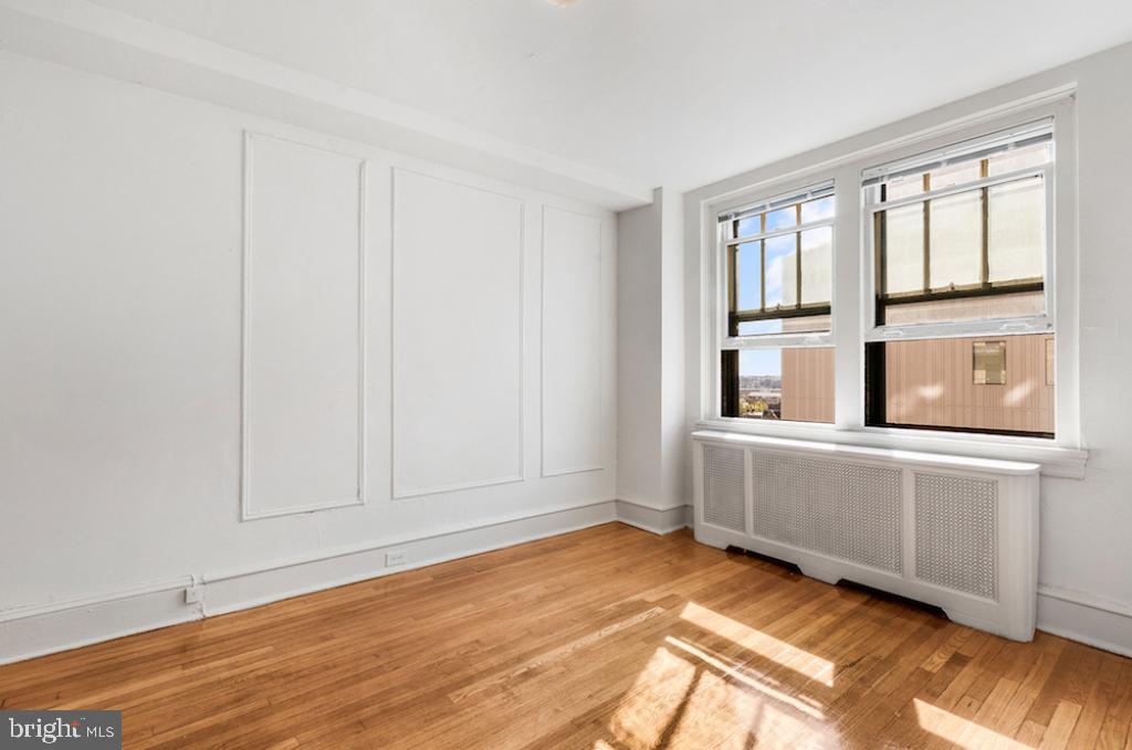 2100-02 Walnut Street, Unit 2M Philadelphia, PA 19103 - Photo 1 of 15 a view of an empty room with window and wooden floor