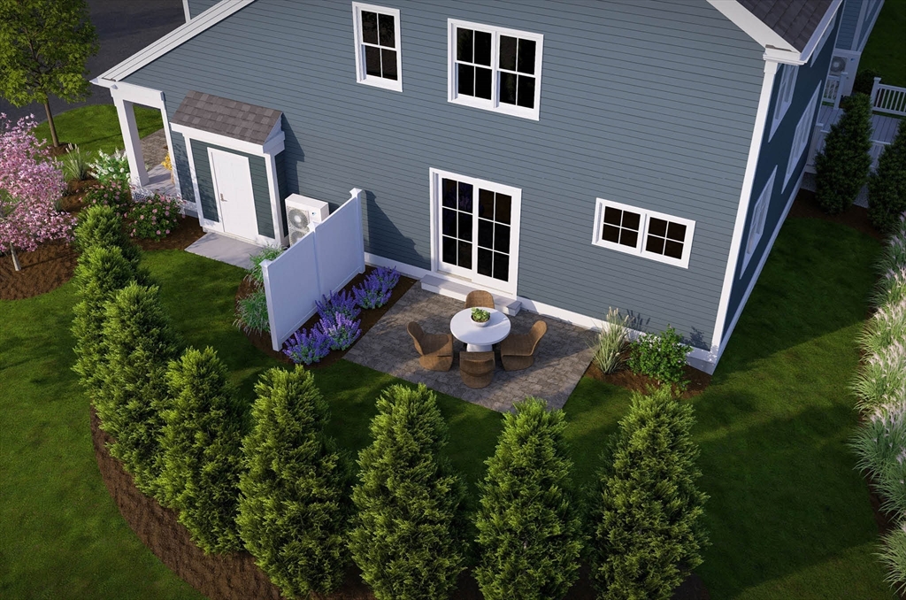 1 Maplewood Lane, Unit 333 Raynham, MA 02767 - Photo 5 of 18 a backyard of a house with table and chairs and wooden fence