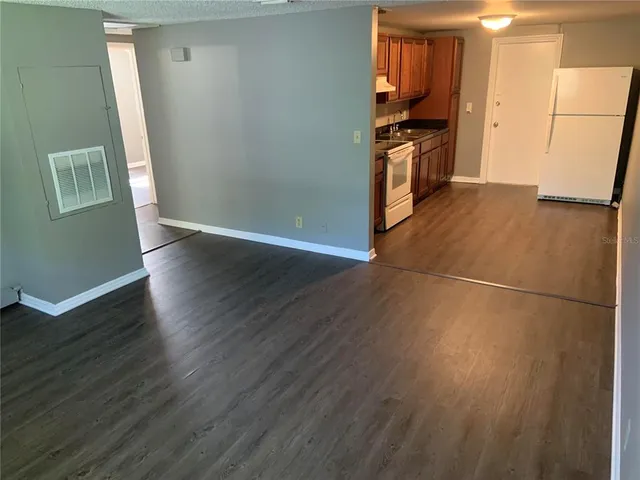 a kitchen with granite countertop a refrigerator and a stove top oven