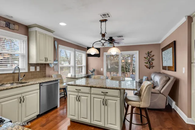 a kitchen with center island cabinets and wooden floor