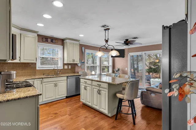 a kitchen with kitchen island granite countertop a sink appliances and cabinets