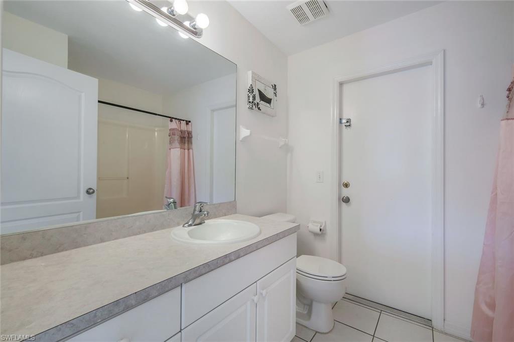 807 Rocaille Avenue Fort Myers, FL 33913 - Photo 20 of 25 a bathroom with a granite countertop sink a toilet and a mirror