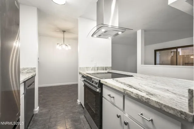 a kitchen with a granite countertop sink and refrigerator