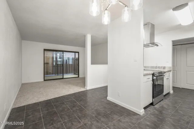 a view of a kitchen with a stove cabinets and a floor to ceiling window