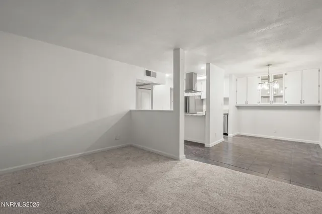 an empty room with a cabinet and mirrors