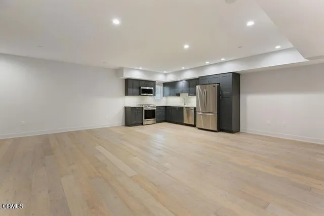 a view of an empty room with a kitchen