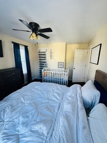 a bedroom with a bed that has a blanket on it and next to a window