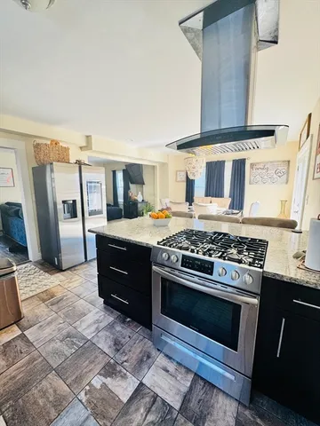 a kitchen with stainless steel appliances granite countertop a stove a sink and a refrigerator