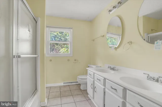 a bathroom with a sink toilet a mirror and shower