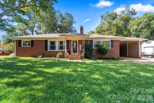 a view of a house with a yard and potted plants