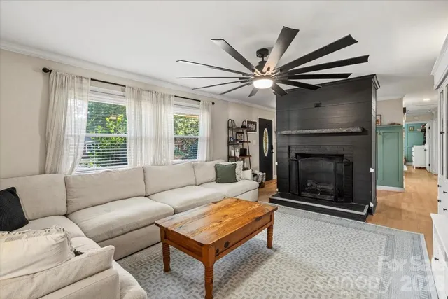a living room with furniture ceiling fan and a window