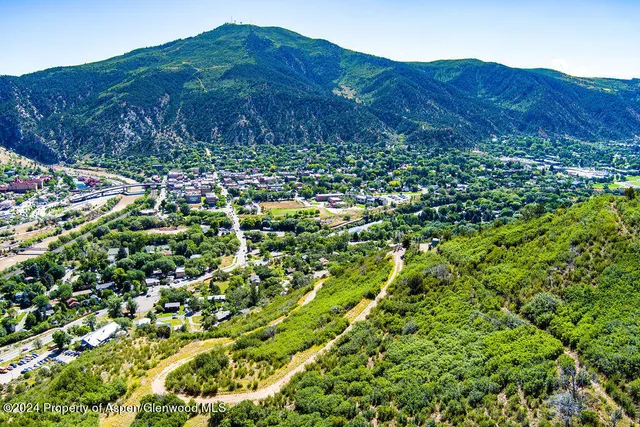 a view of a lush green field with mountains in the background