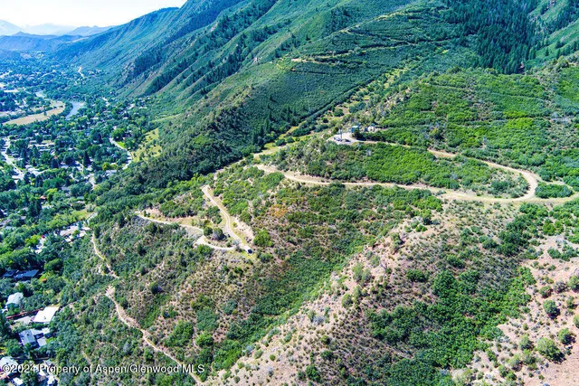 a view of a lush green hillside and a building in the background