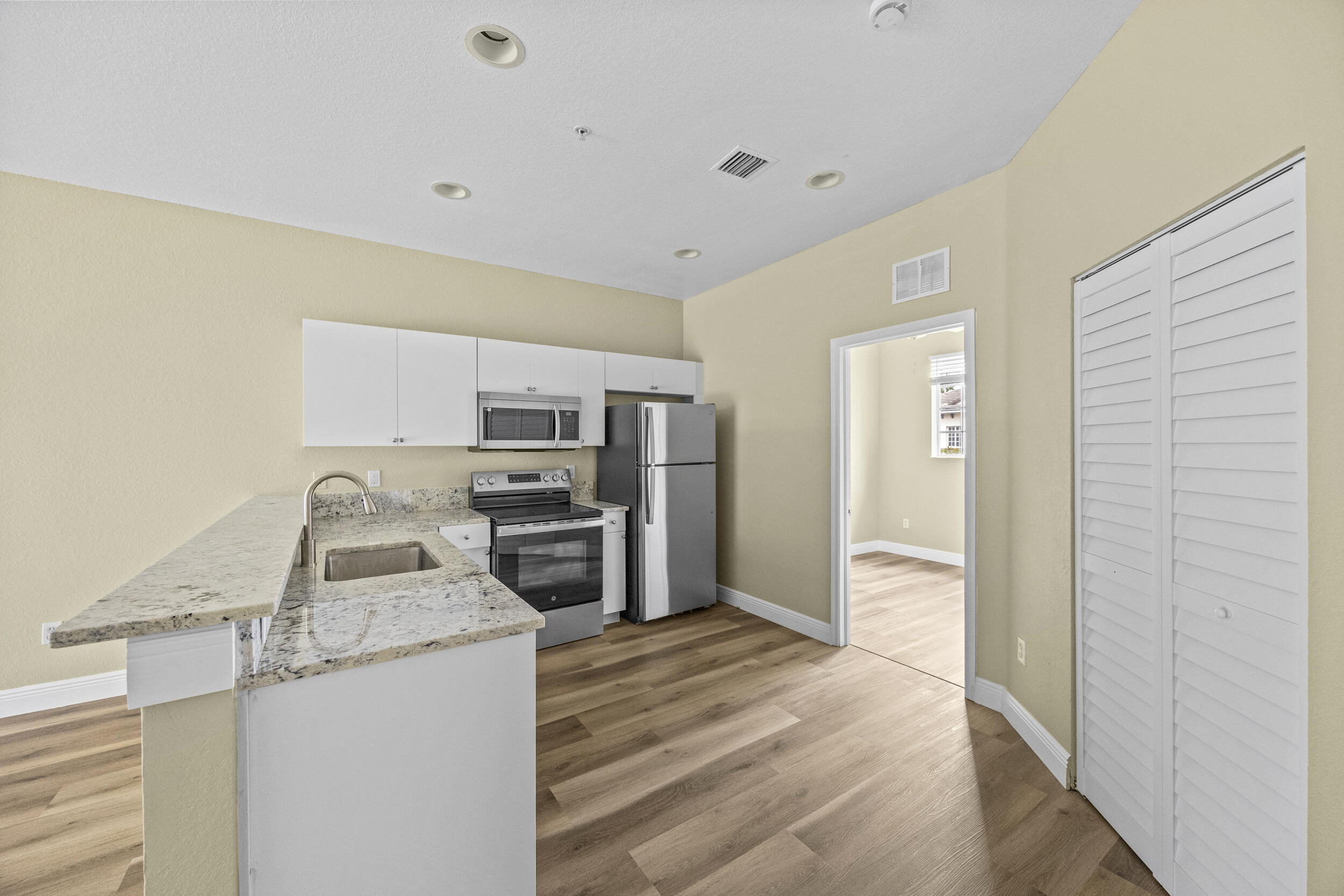 1982 Freeport Drive Riviera Beach, FL 33404 - Photo 9 of 29 a kitchen with granite countertop a refrigerator and a sink