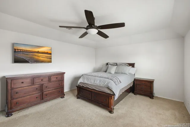 a spacious bedroom with a bed and a dresser