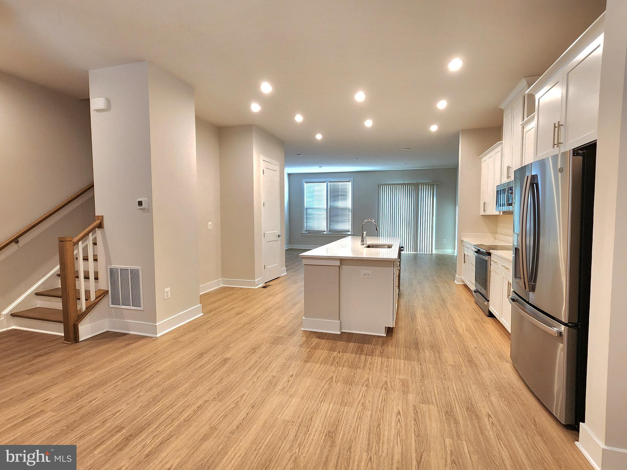 2391 Liberty Loop Herndon, VA 20171 - Photo 19 of 29 a kitchen with stainless steel appliances a refrigerator and wooden floor