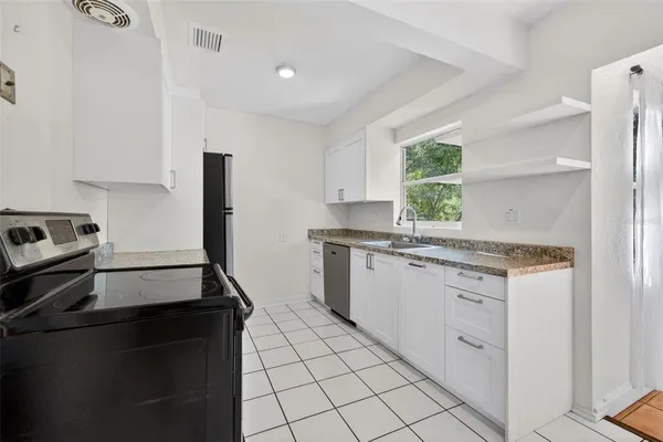 a kitchen with granite countertop cabinets and window