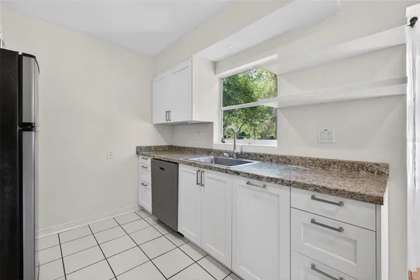 a kitchen with a sink cabinets and window