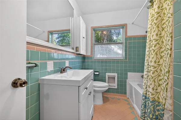 a bathroom with a sink toilet and window