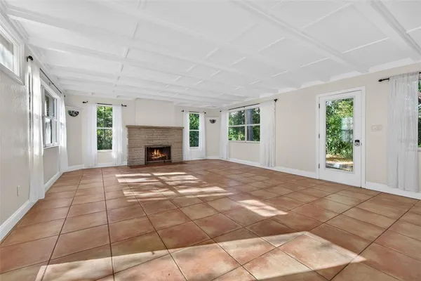 a view of empty room with fireplace and windows