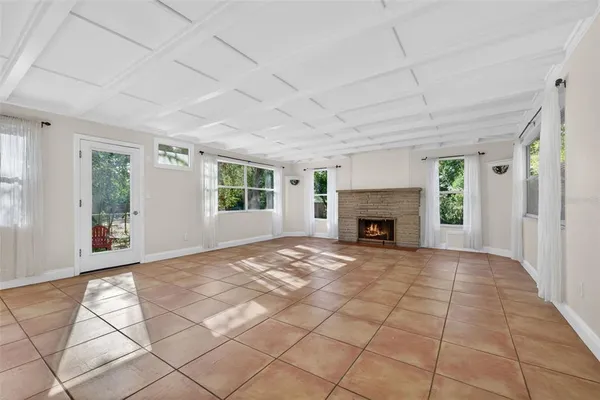 a view of an empty room with window and fire place