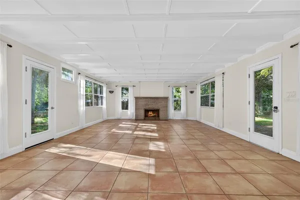 a view of an empty room with window and fire place