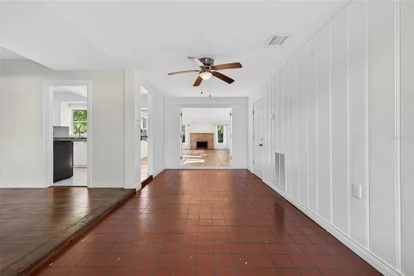 a view of a living room with a chandelier fan and kitchen view