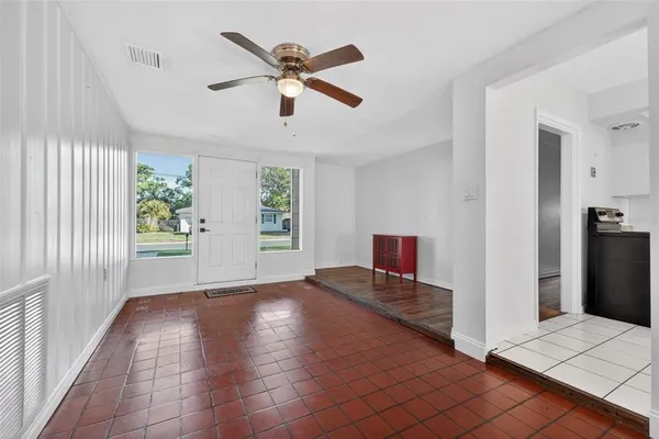 a view of a hallway with wooden floor and a ceiling fan