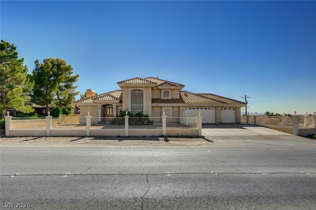 640 North Racetrack Road Henderson, NV 89015 - Photo 2 of 65 Elegant fencing surrounds this property, featuring a tile roof and expansive driveway.