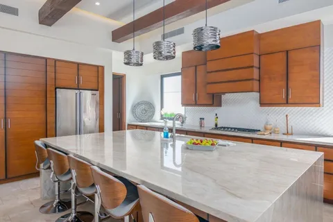 a kitchen with stainless steel appliances granite countertop a sink a table and chairs