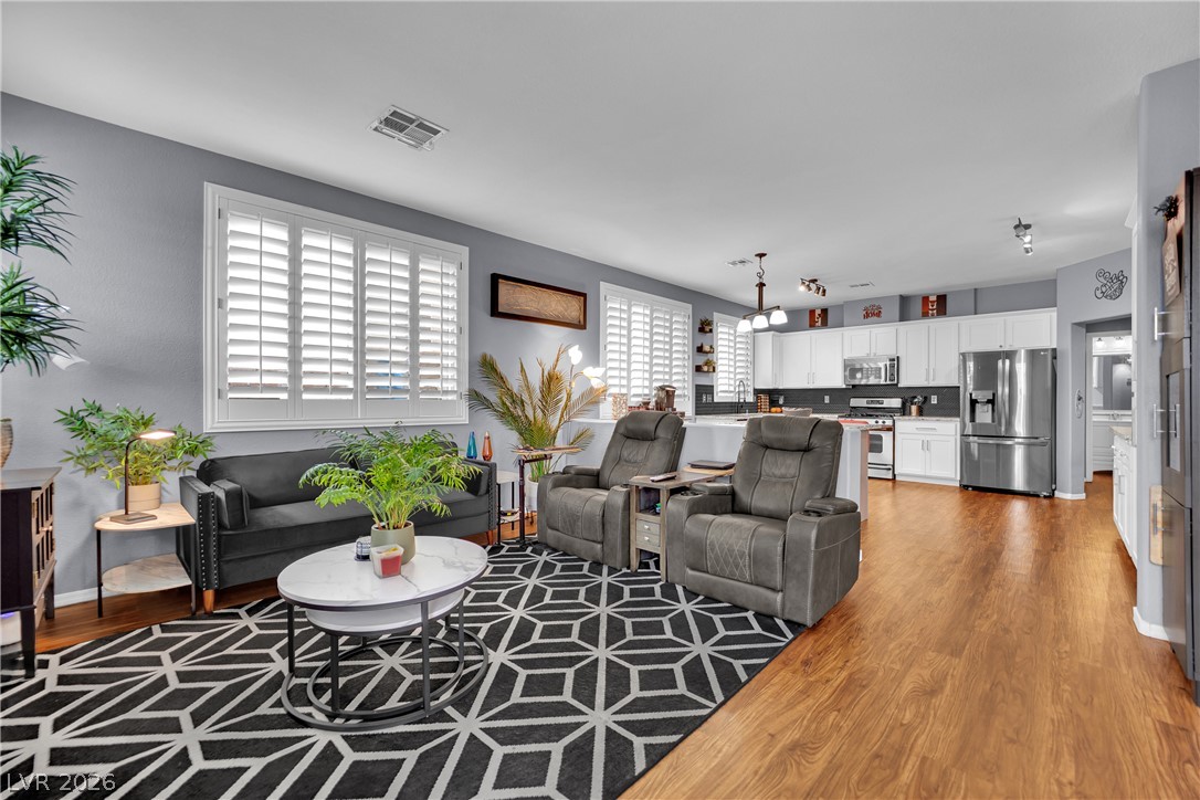 1724 Millstream Way Henderson, NV 89074 - Photo 11 of 60 An inviting open-concept living area boasts lustrous hardwood flooring throughout and features a spacious kitchen.