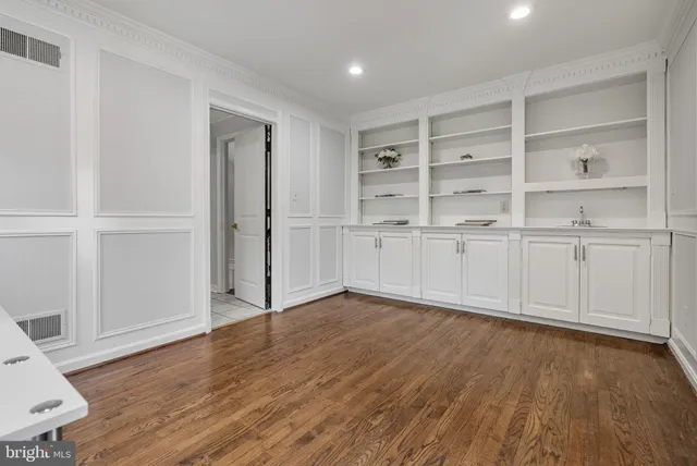 a view of a livingroom with wooden floor and furniture