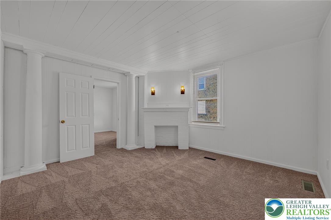 313 Main Street Slatington, PA 18080 - Photo 12 of 73 A cozy bedroom features carpeted flooring and a charming white fireplace, ready for personal touches.