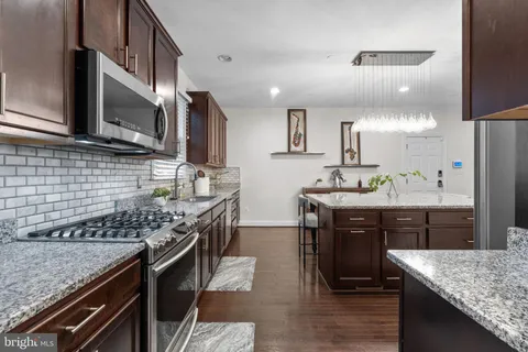 a kitchen with stainless steel appliances granite countertop a sink stove and cabinets