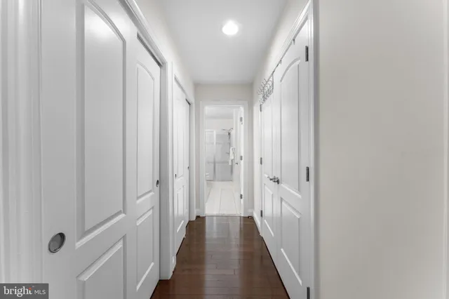 a view of a hallway with wooden floor and staircase