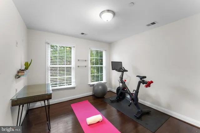 a living room with furniture gym equipment and windows