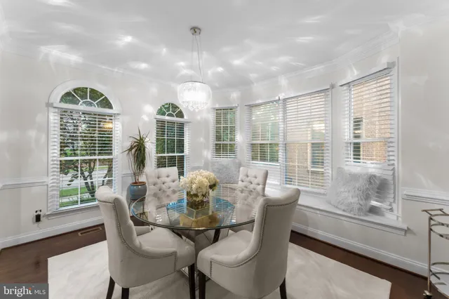 a dining room with furniture large windows and wooden floor