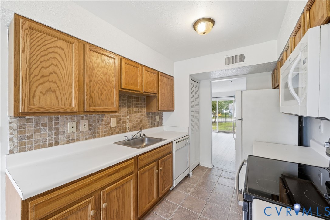 1501 Ivymount Road Richmond, VA 23225 - Photo 4 of 31 Wood cabinetry with white countertops, stainless s